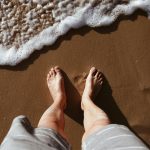 Man walking barefoot at the beach.